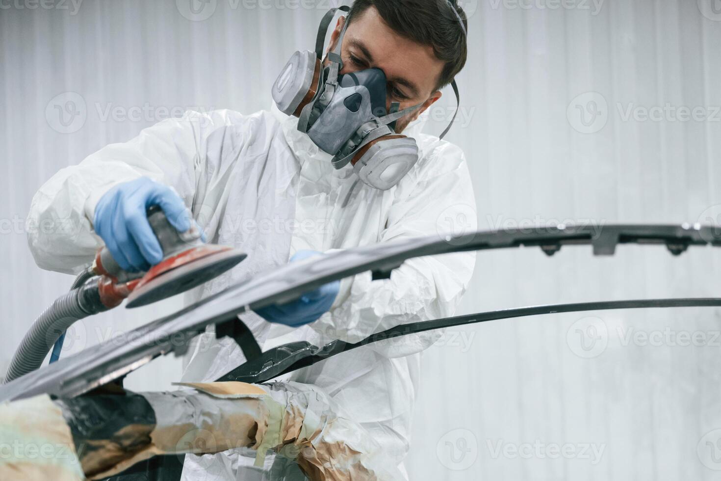 Polishing ,the surface. Repairman,is working with carcass of the car in the garage photo