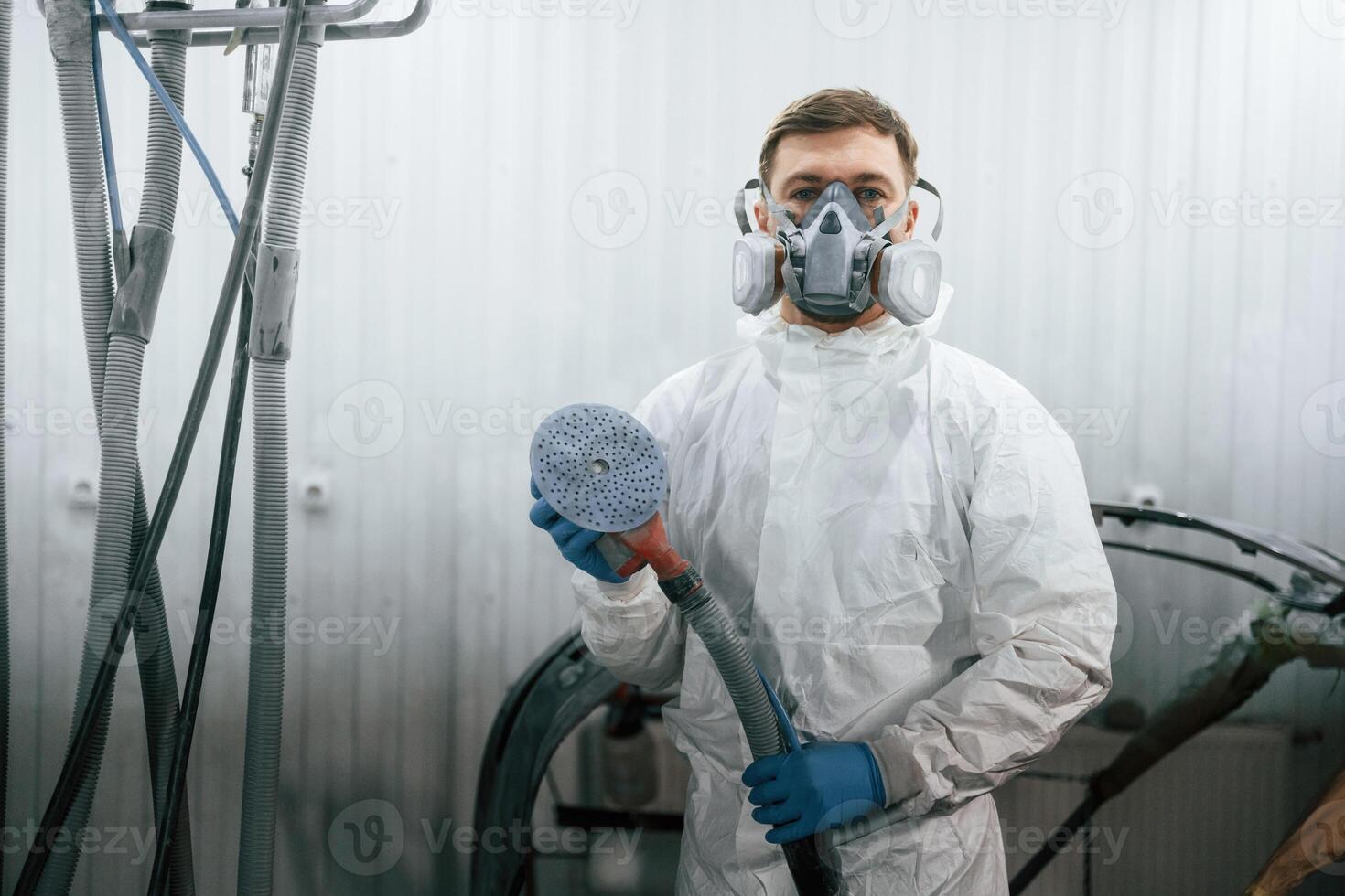 With ,professional equipment. Repairman, is working with carcass of the car in the garage photo