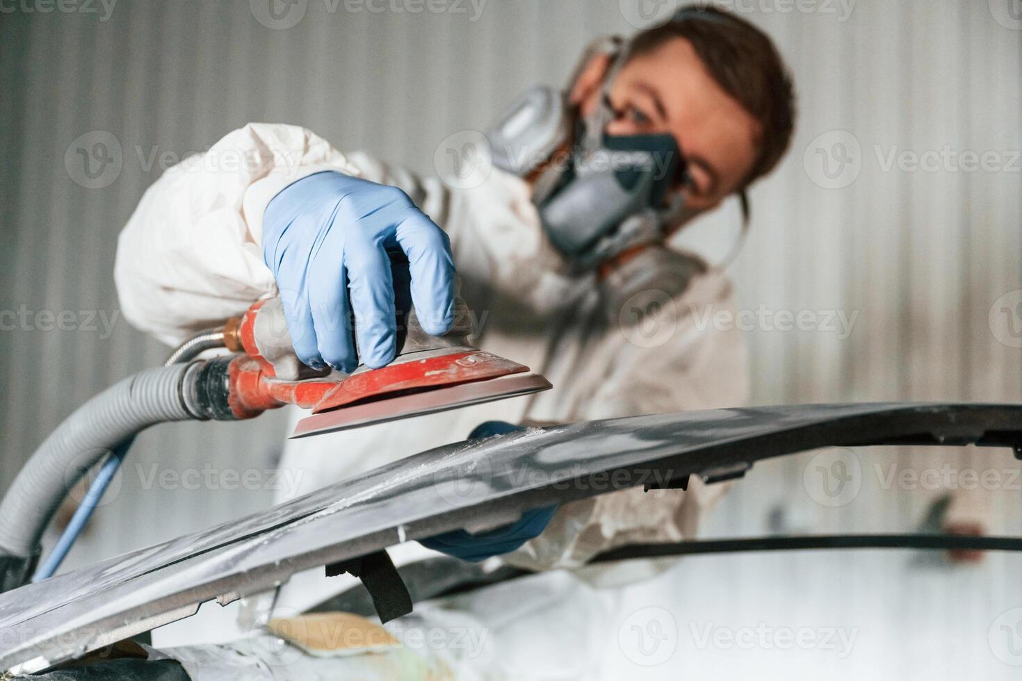 Polishing the surface. Repairman, is working with carcass of the car in the garage photo