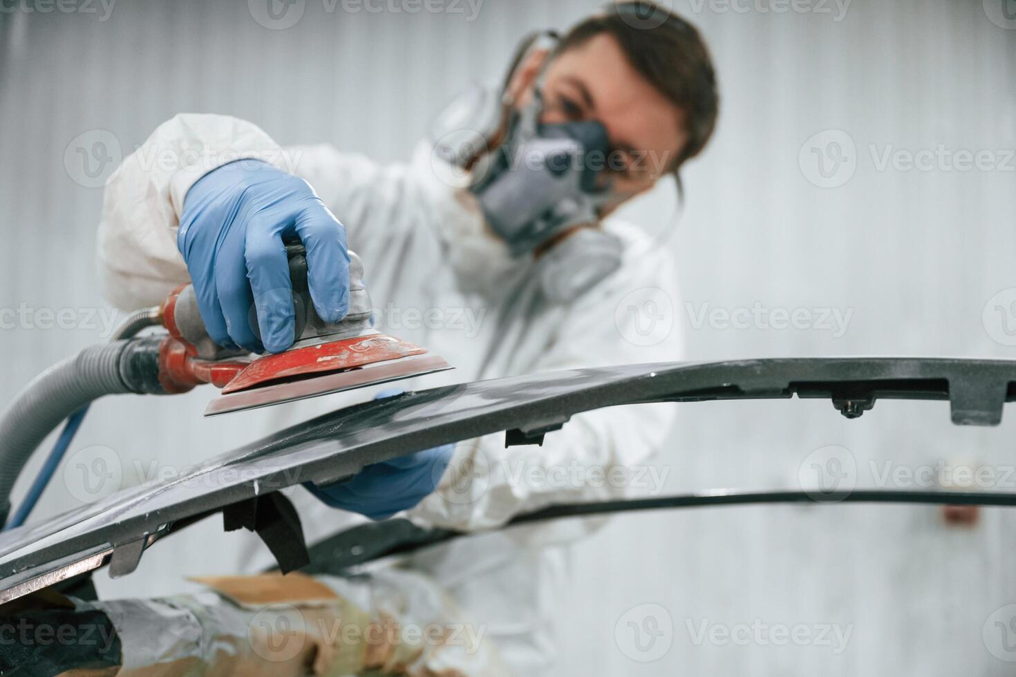 Polishing, the surface. Repairman is working with carcass of the car in the garage photo