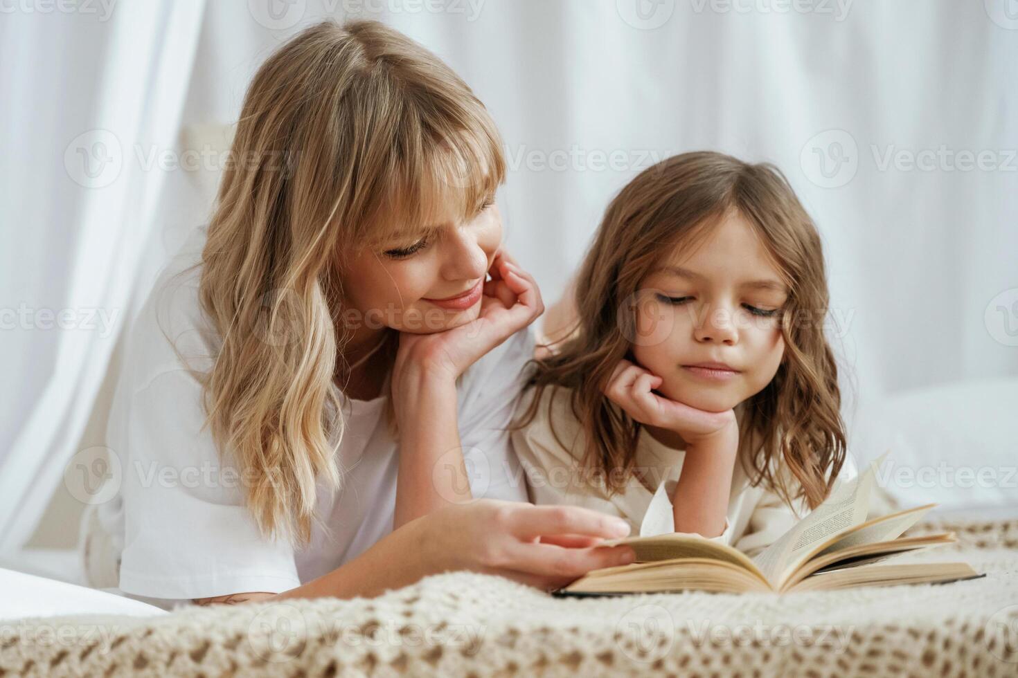 Reading, the book together. Mother ,with daughter are at home photo