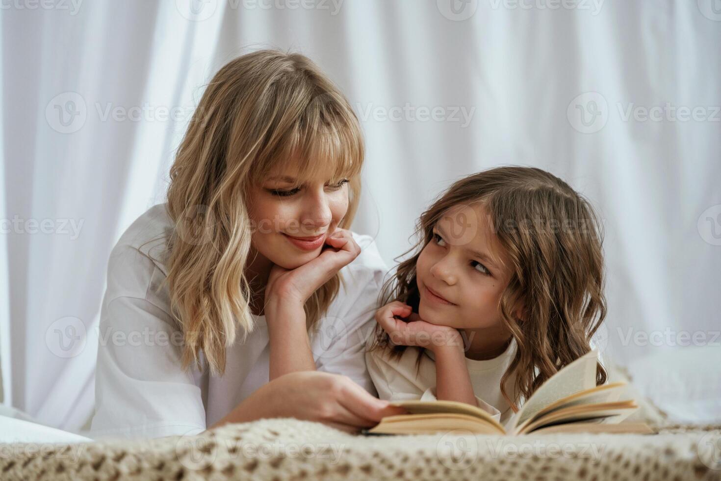 Reading ,the,, book together. Mother with daughter are at home photo