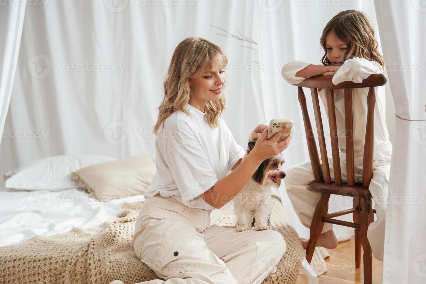 Dog pet is with them. ,Mother with daughter are at home together photo