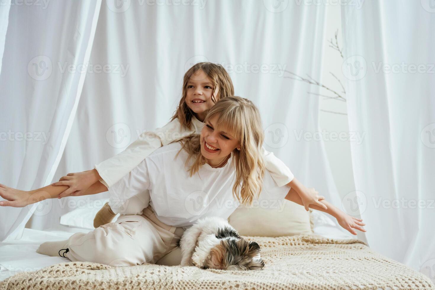 Wellness,, having fun on the bed. Mother with daughter are at home together photo