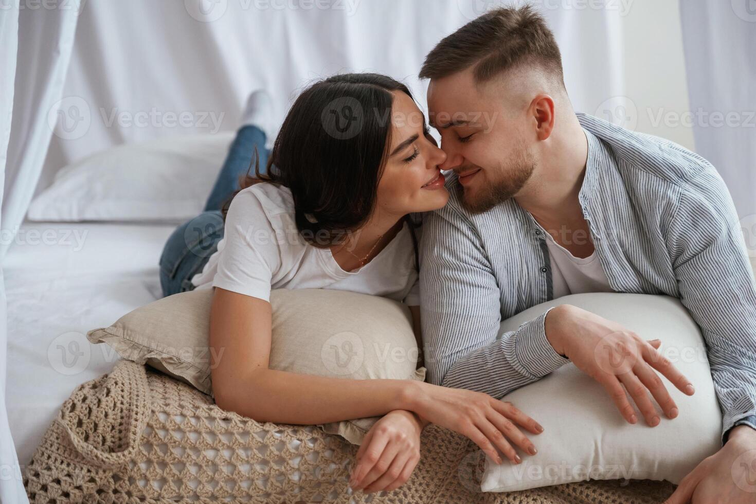Cheerful mood, lying down on bed.,, Young couple are together at home photo