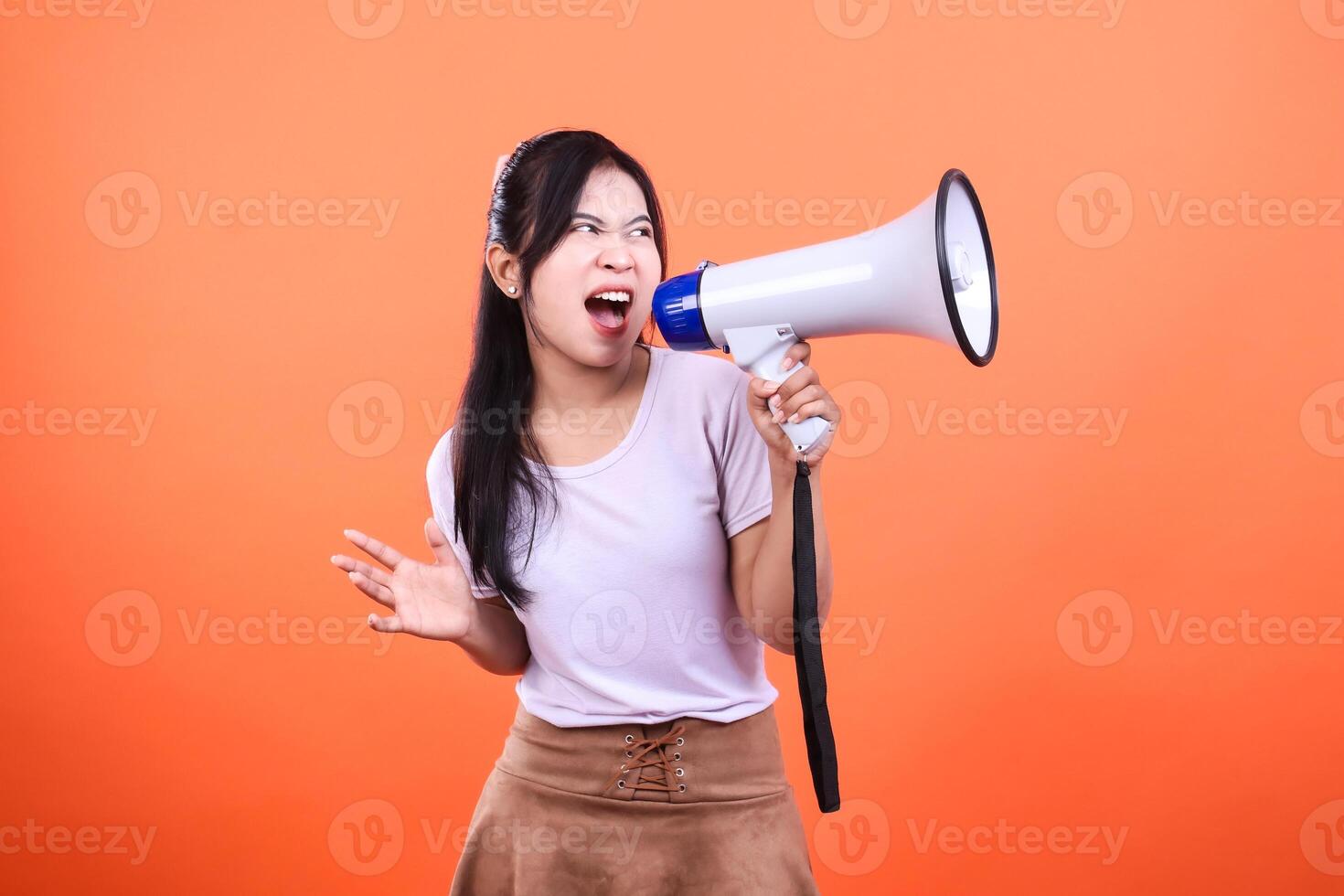 Woman Using Megaphone on Orange Background, Making an Announcement or Protest photo