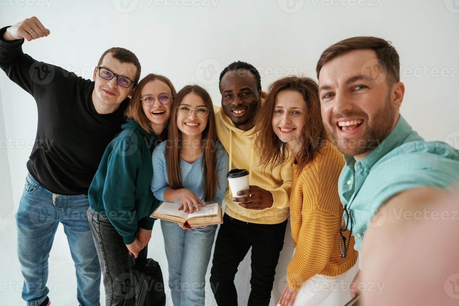 Positive, friends. Group of young people are standing against white background photo