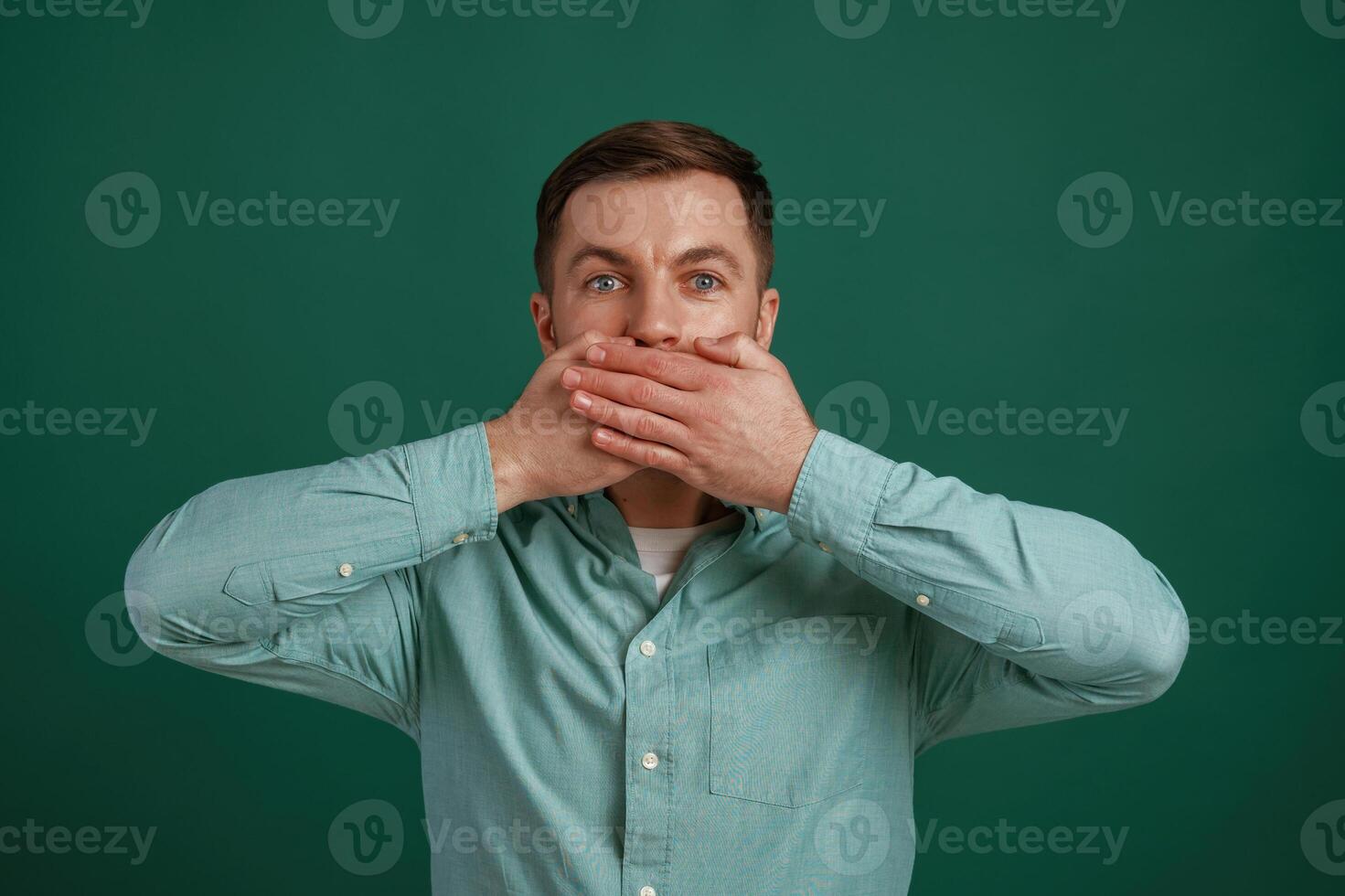Shocked, facial ,,expression. Man is standing against background in the studio photo