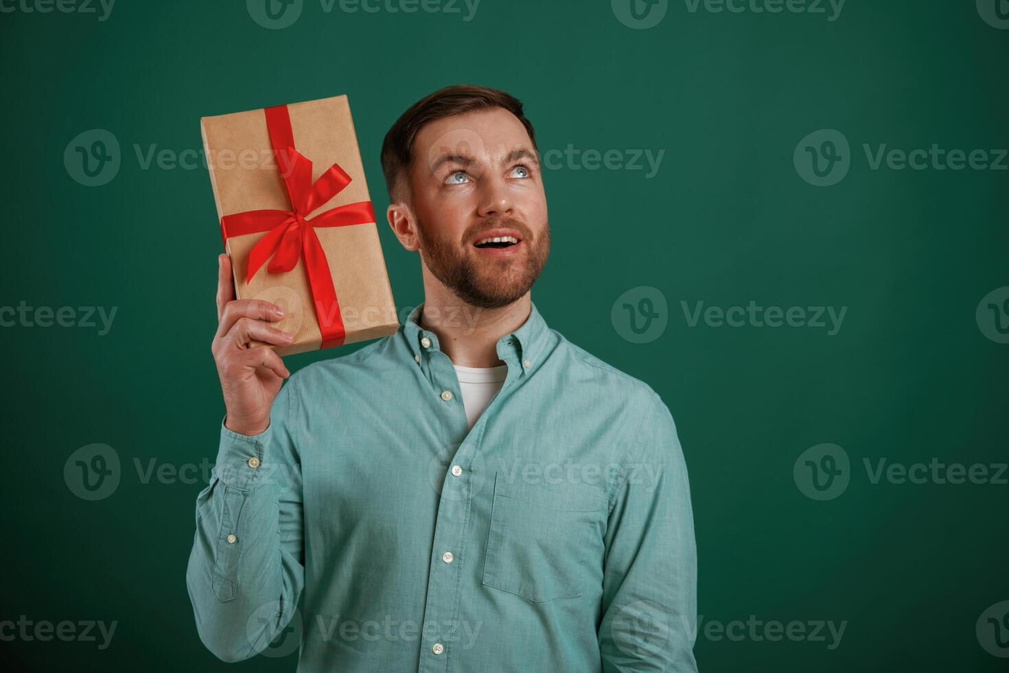 Conception of holidays, with gift box... Man is standing against background in the studio photo
