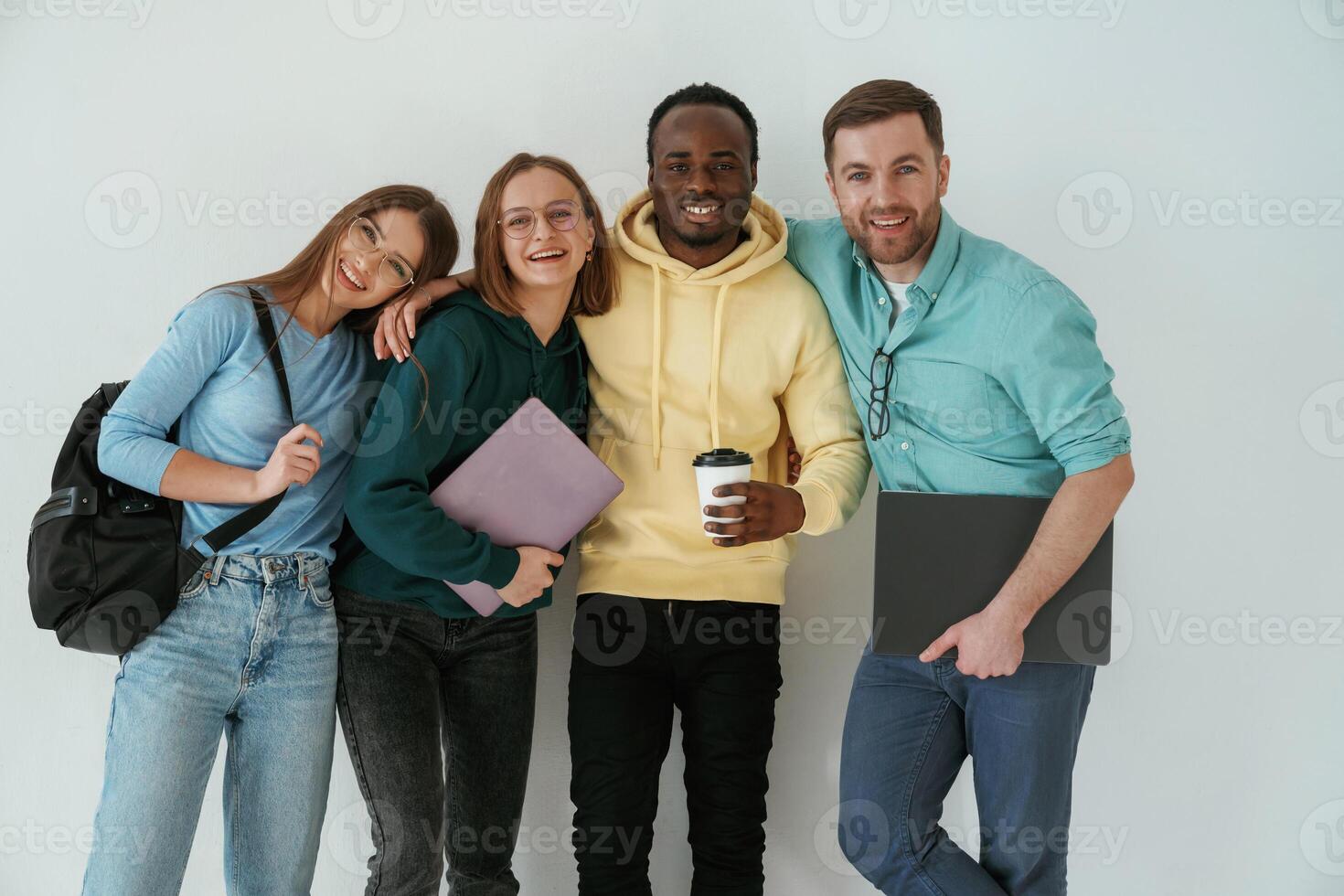 Smiling, looking, forward.. Group of young people are standing against white background photo