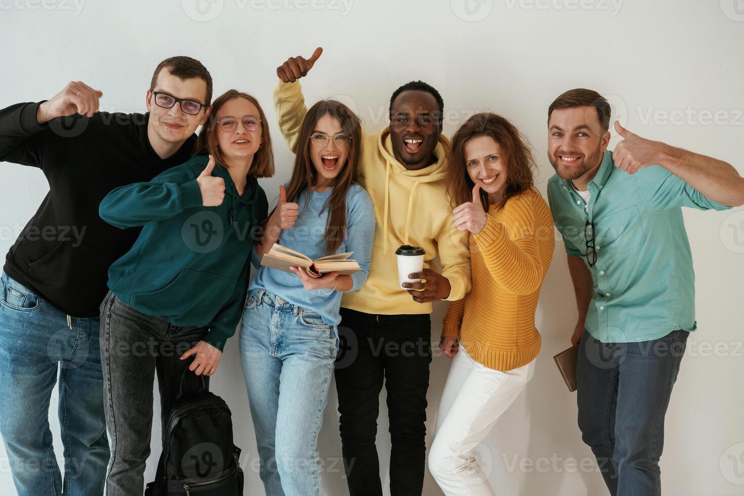 Standing, against white background. Group of young people are together photo