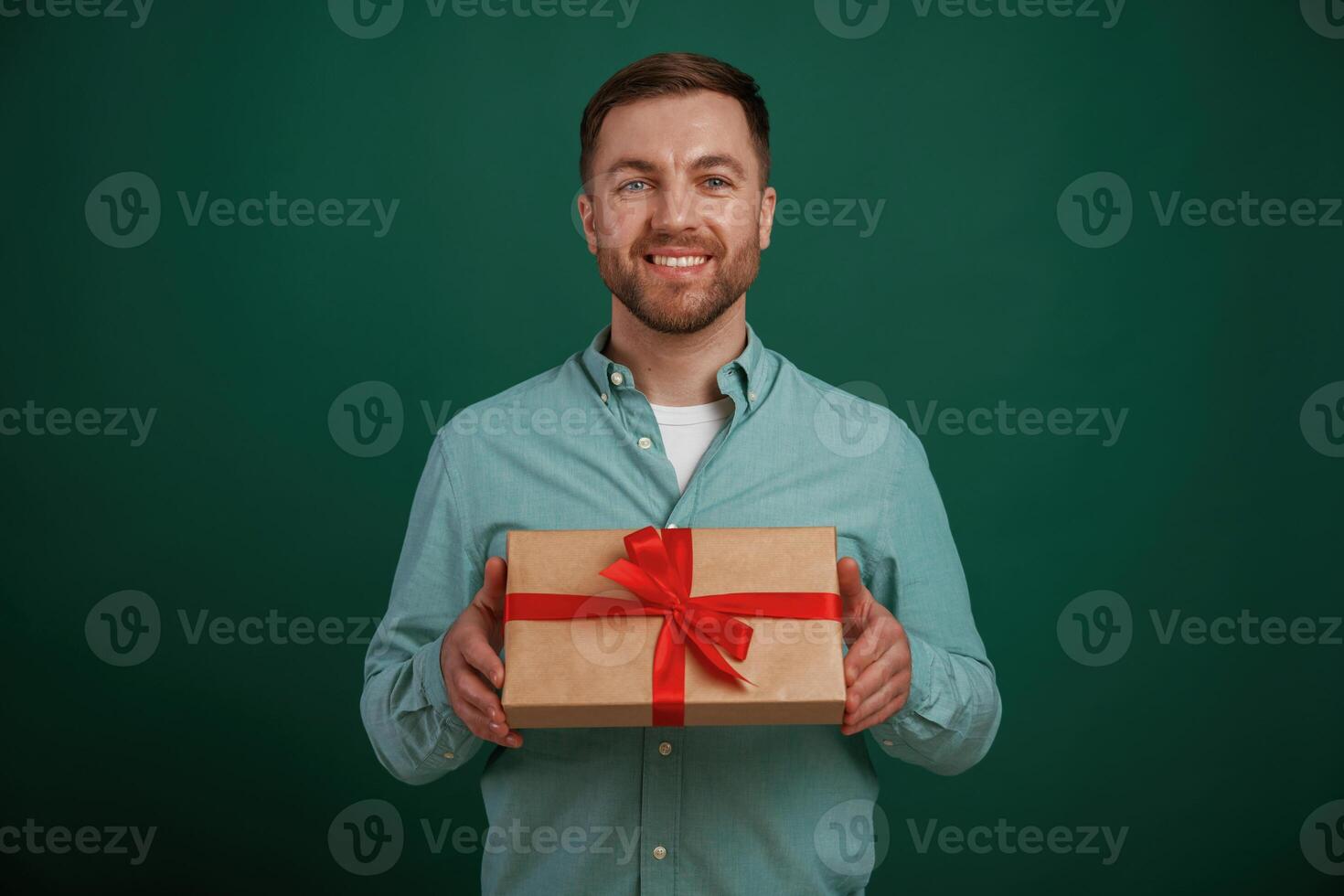 Little ,gift ,box in hands. Man is standing against background in the studio photo
