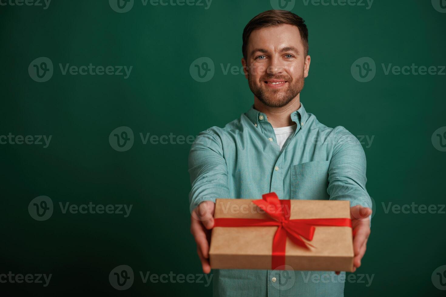 Conception of holidays,, with gift box. Man is standing against background in the studio photo