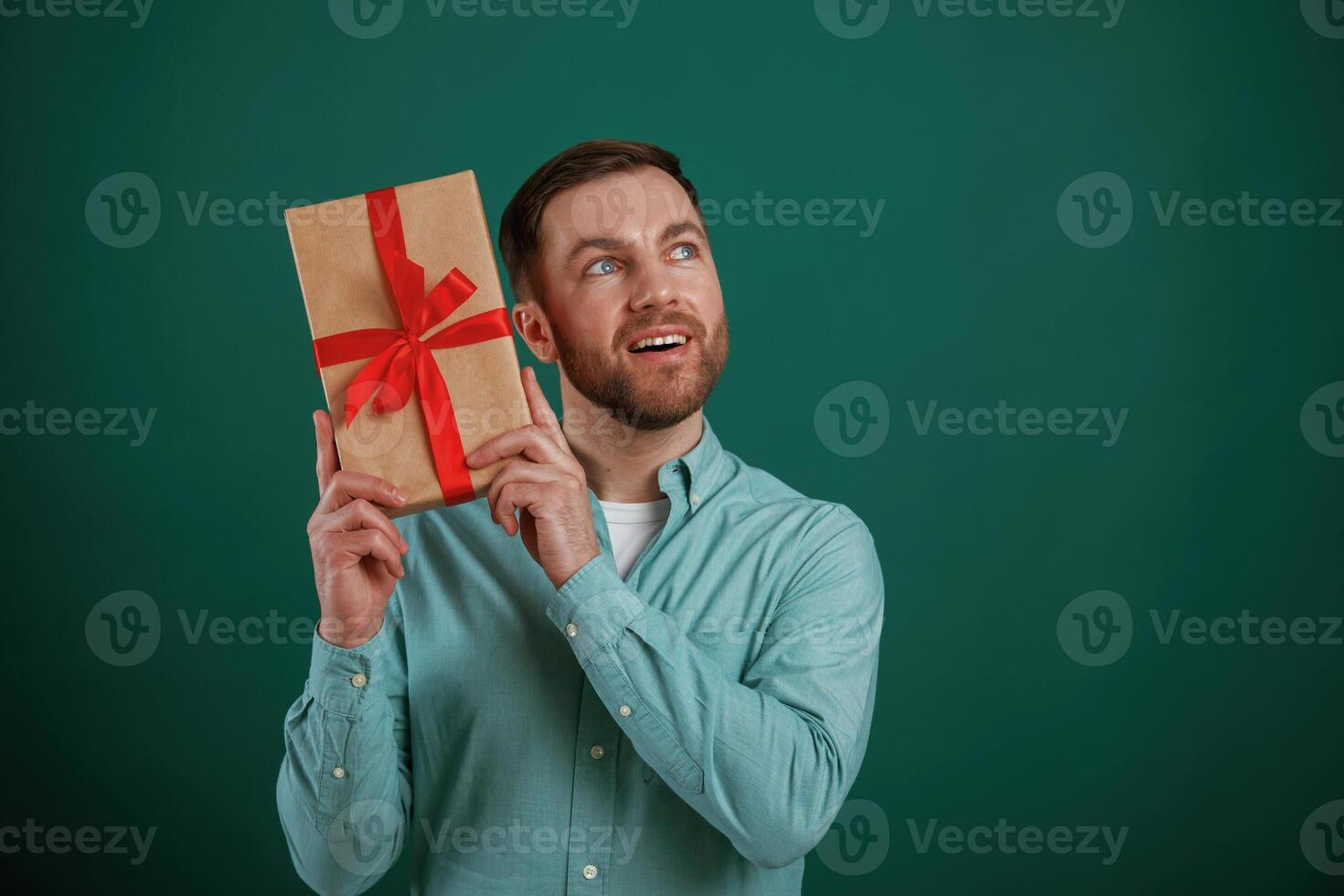 Conception of, holidays, with gift box. Man is standing against background in the studio photo