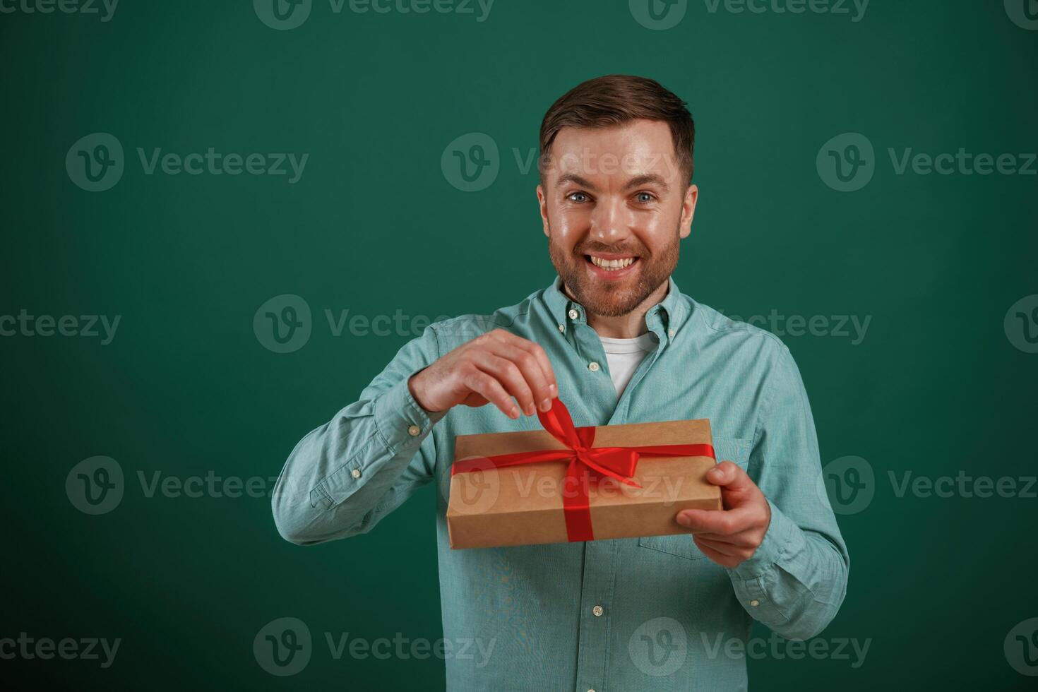 Conception,of holidays, with gift box. Man is standing against background in the studio photo