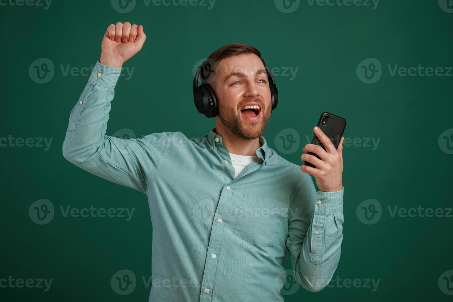 Smiling, enjoying ,music.. Man is standing against background in the studio photo