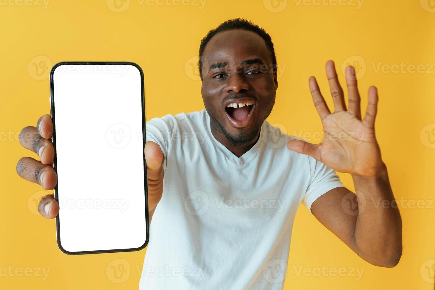 White display of smartphone, for,, copy space. Black man is in the studio against yellow background photo