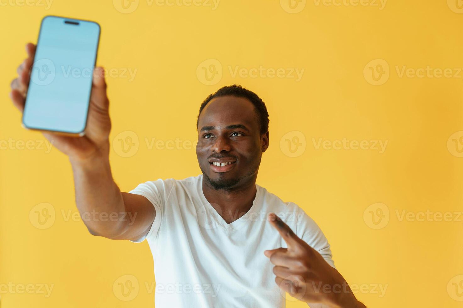 Empty, display of smartphone, holding.. Black man is in the studio against yellow background photo