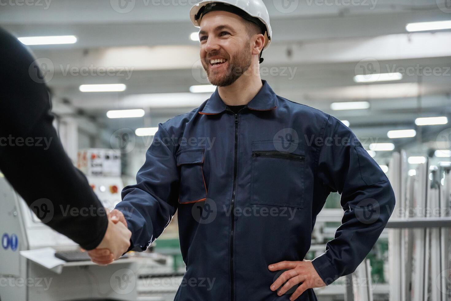 Doing handshake. Man on the factory is making deal with other person,, photo