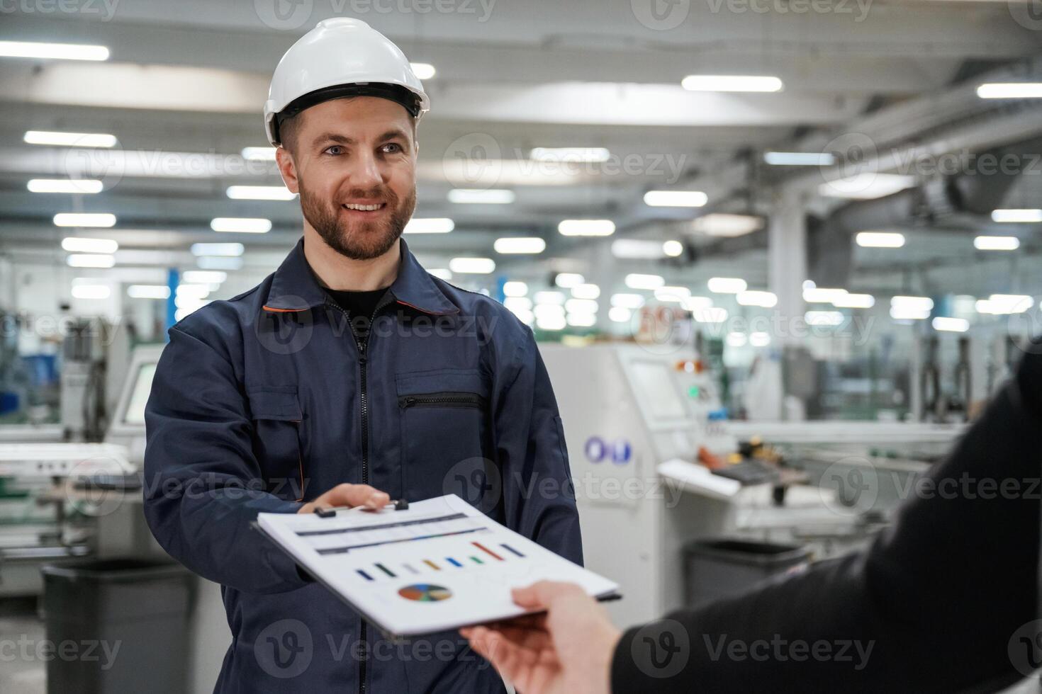 Giving the document with plan. Man on the factory is making deal with other person. photo