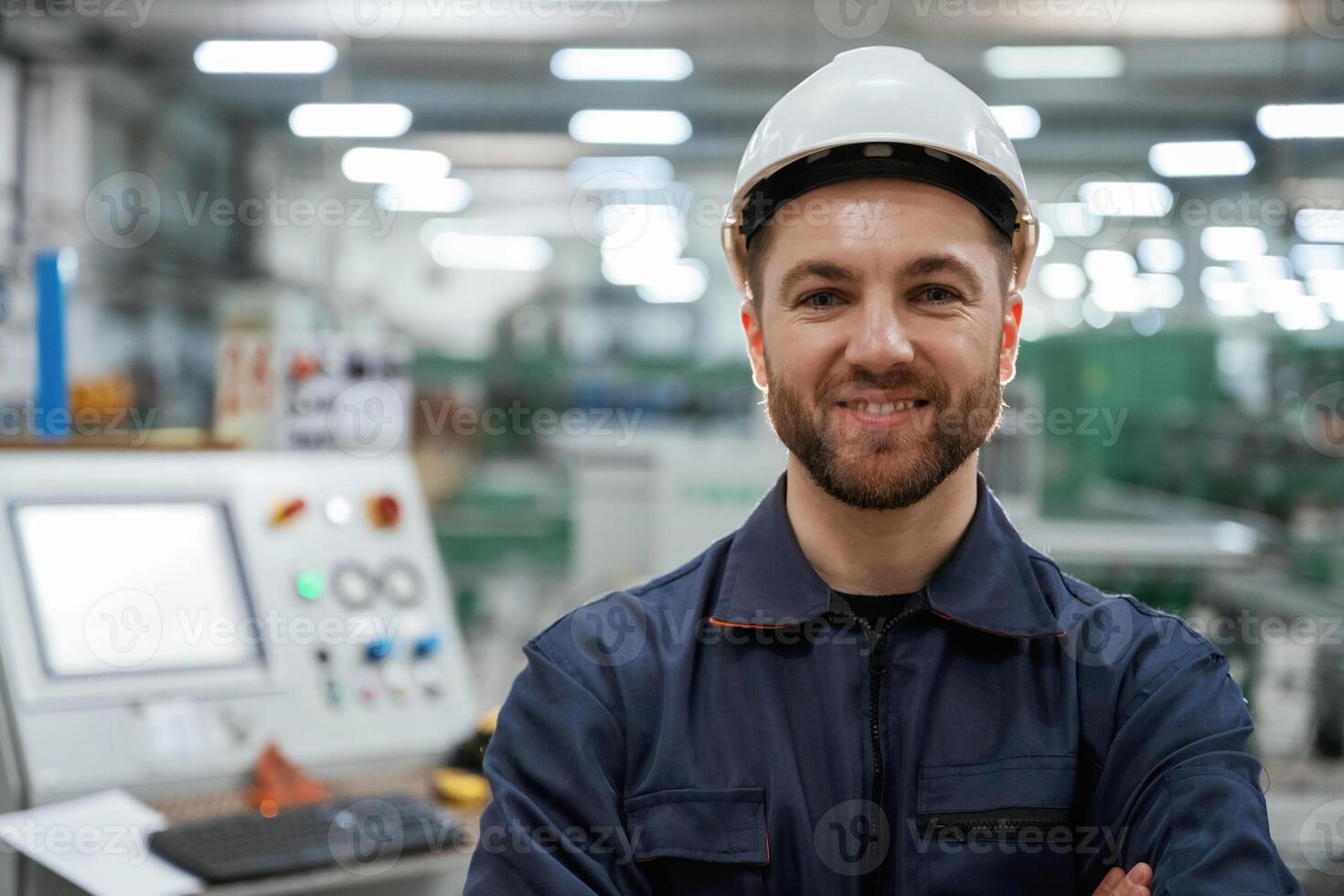 Factory worker is indoors with hard hat photo