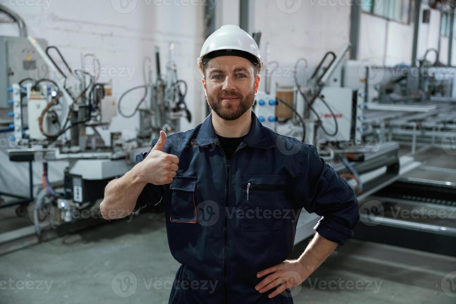 Handsome ,friendly guy. Factory worker, is indoors with hard hat photo