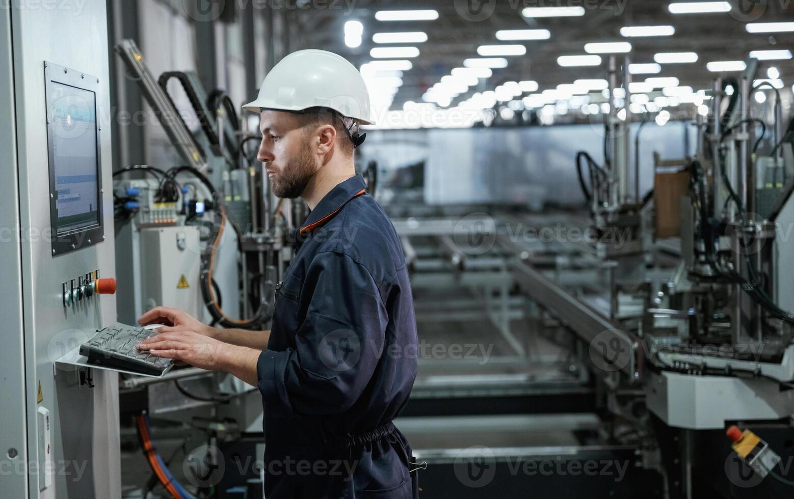 Busy employee. Factory worker is, indoors with hard hat photo