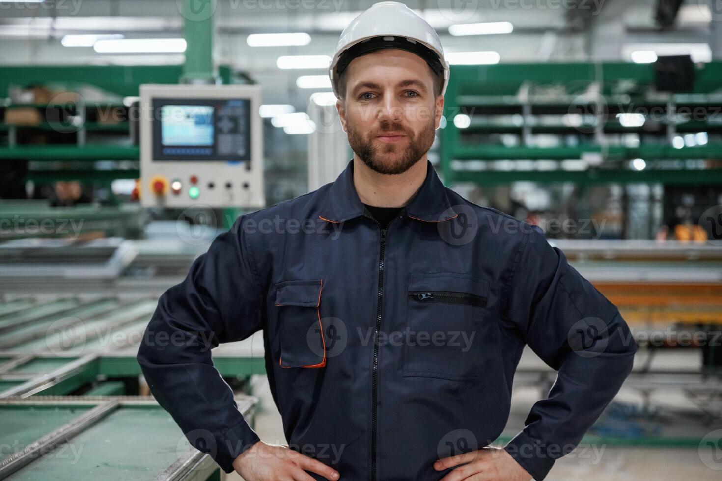 Against ,machine. Factory, worker is indoors with hard hat photo