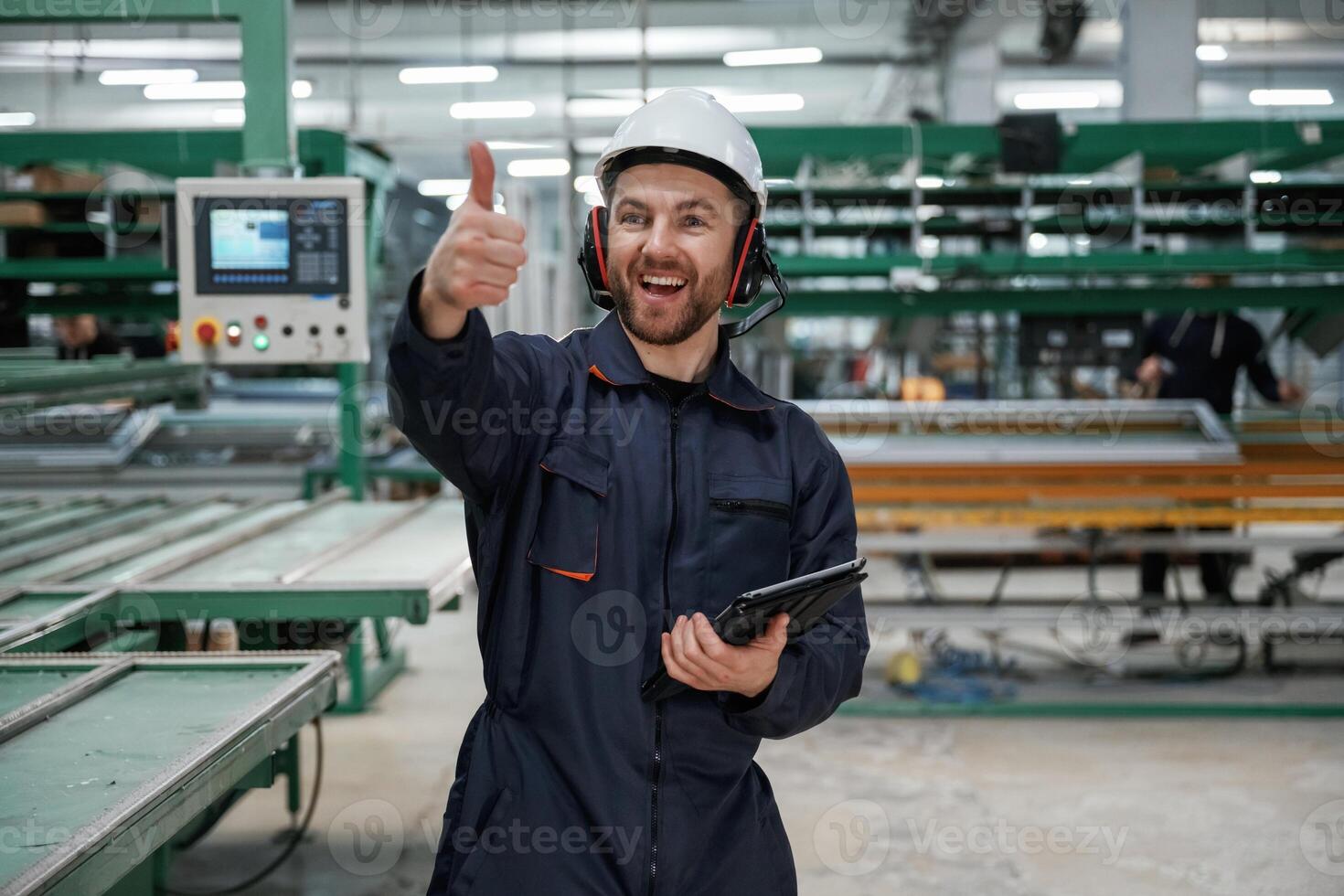 Giving, orders by hand. Factory worker, is indoors with hard hat photo