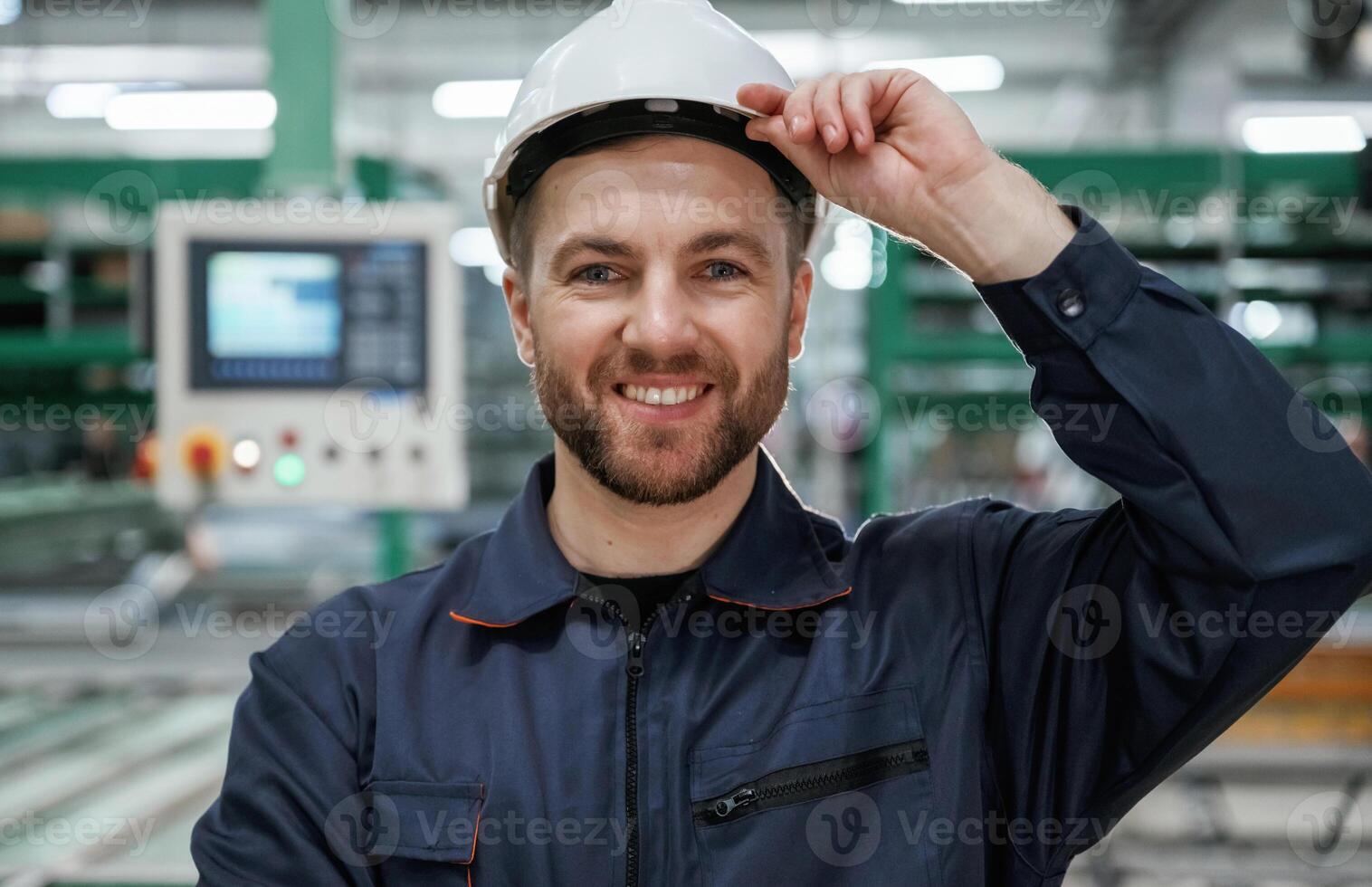 In ,,white hard hat. Factory worker is indoors photo