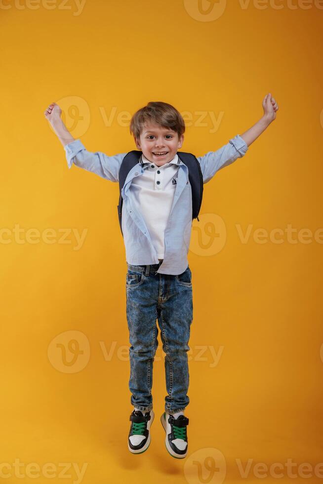 Front, view. Little boy is in the studio against yellow background photo