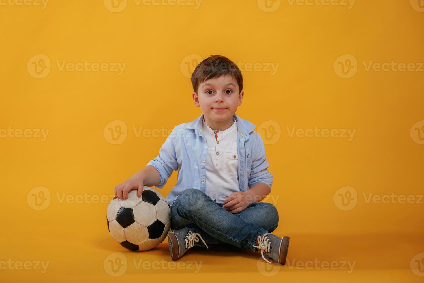 Front ,view. Little boy is in the studio against yellow background photo
