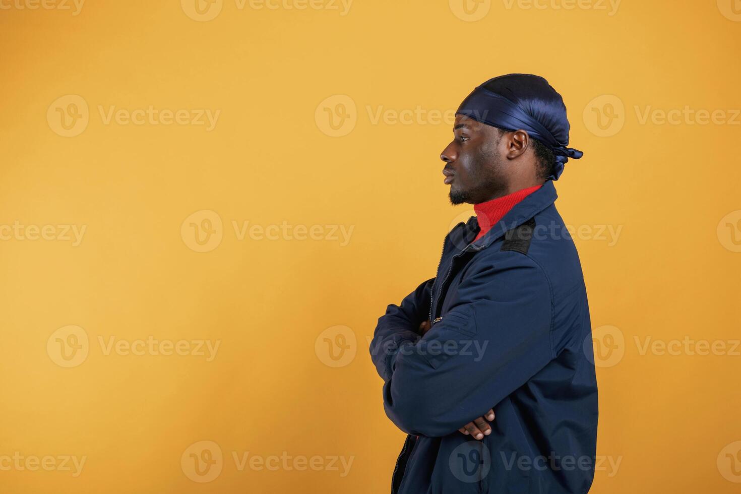 View from, the side. Handsome black man is in the studio against yellow background photo