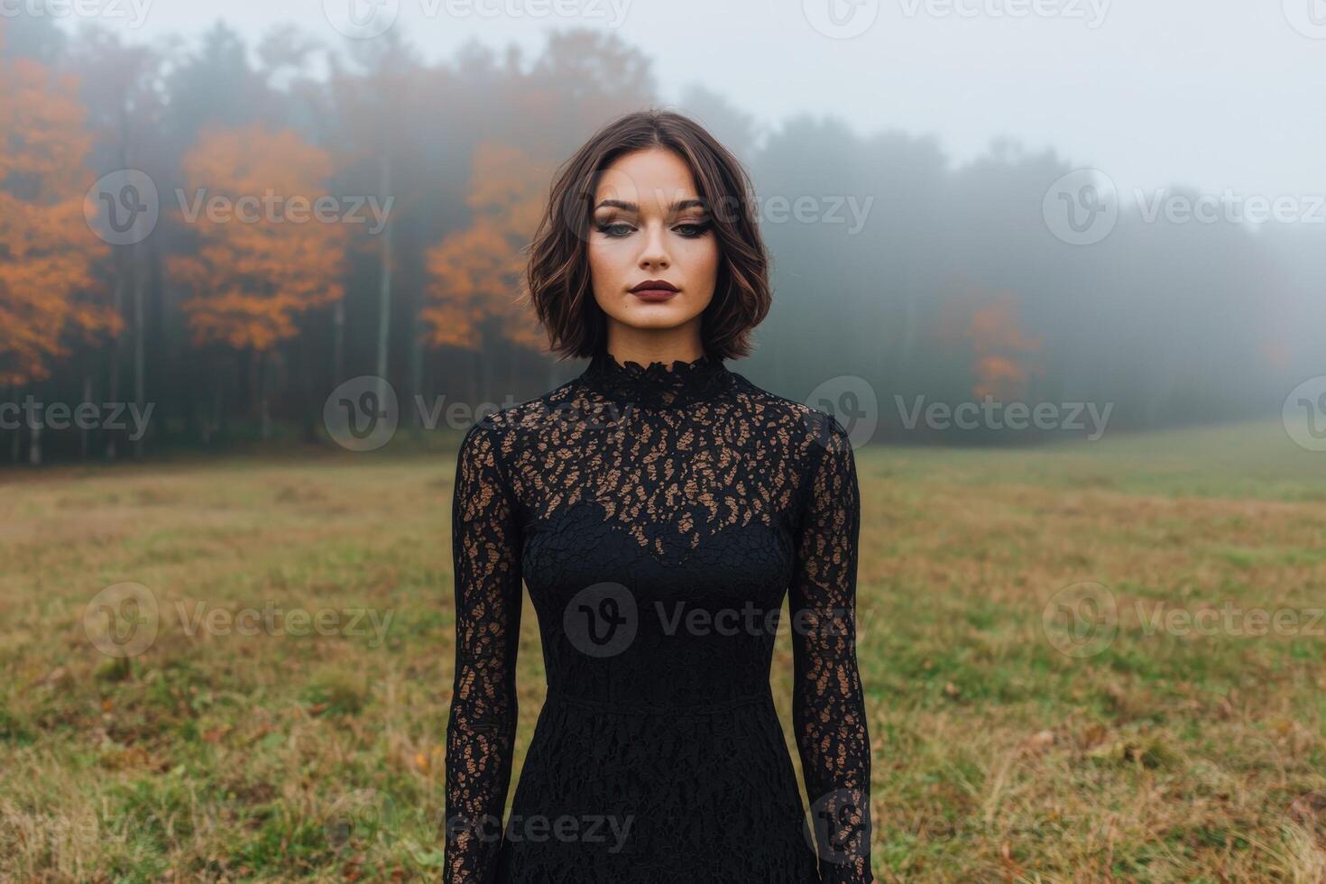 Woman in black lace dress standing in a field photo