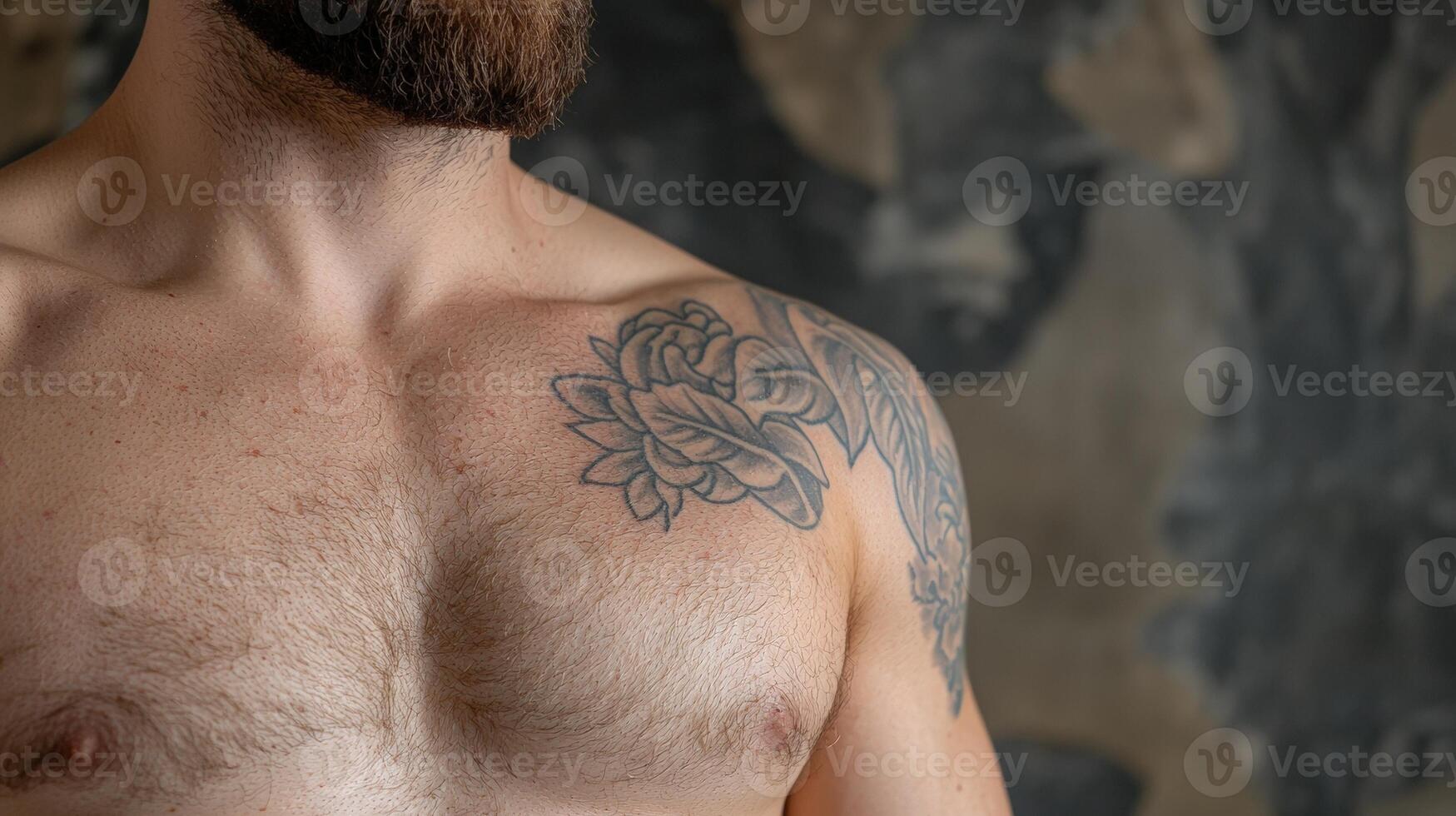 Close up of a mans chest and shoulder with a floral tattoo. photo