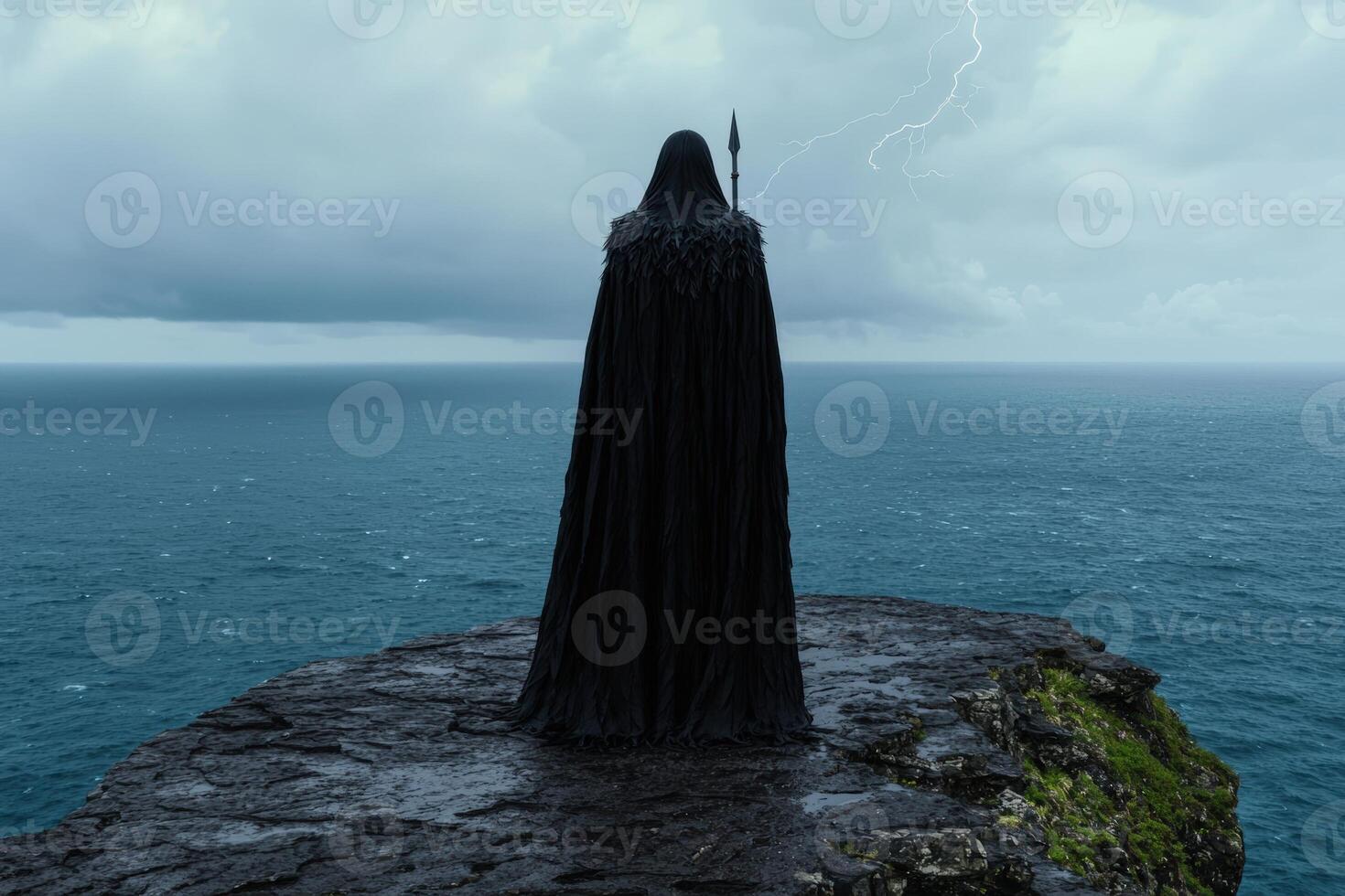 Mysterious figure in black cloak standing on cliff overlooking ocean during a storm photo