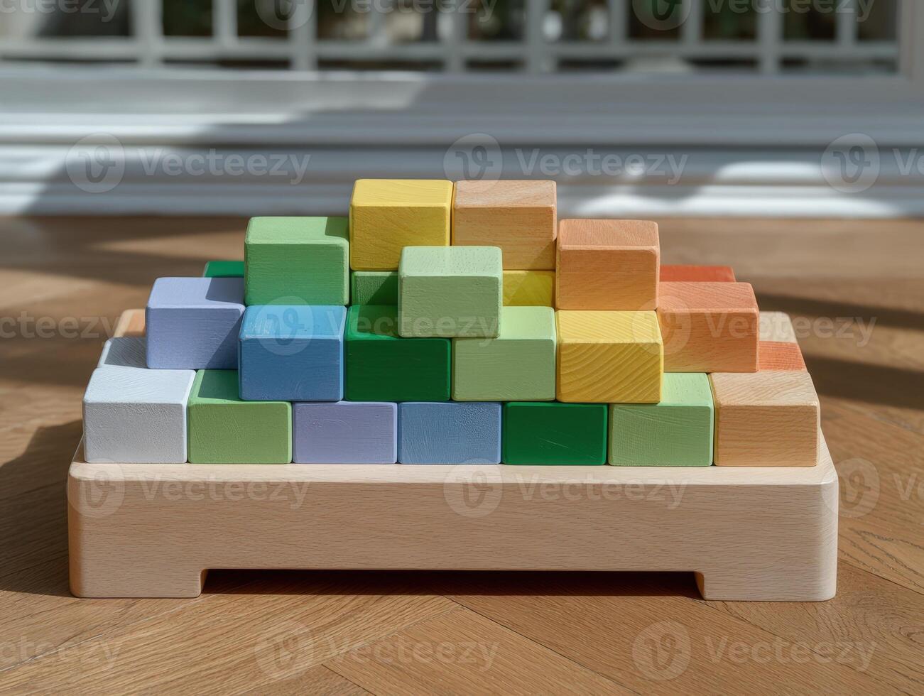 Colorful wooden building blocks arranged in a pyramid on a wooden tray photo