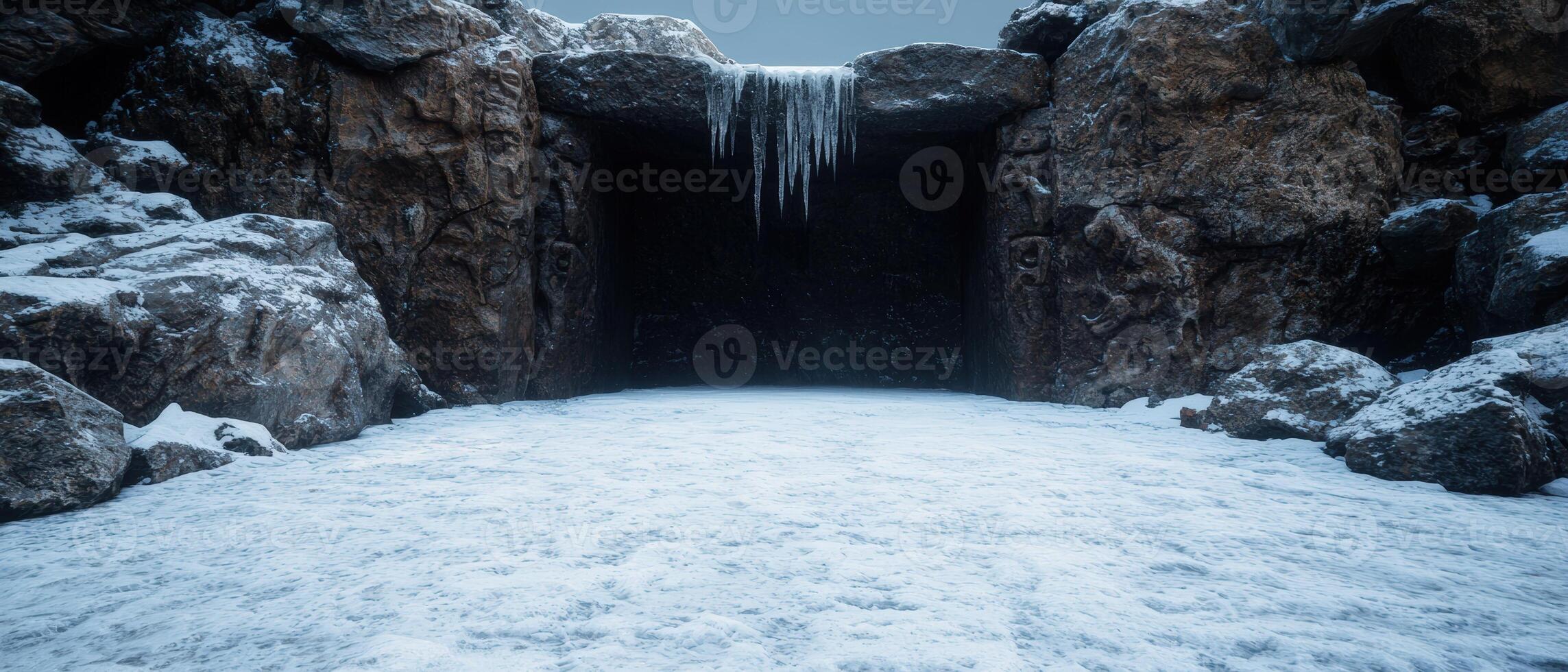 Icy cave entrance with snow covered ground and hanging icicles photo