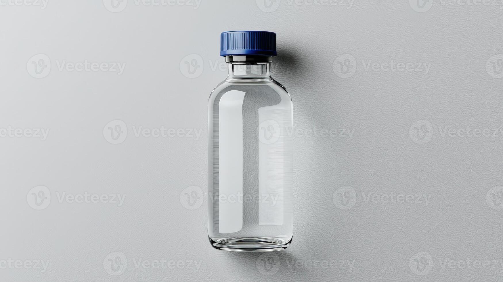 Clear glass bottle with blue cap on gray background photo