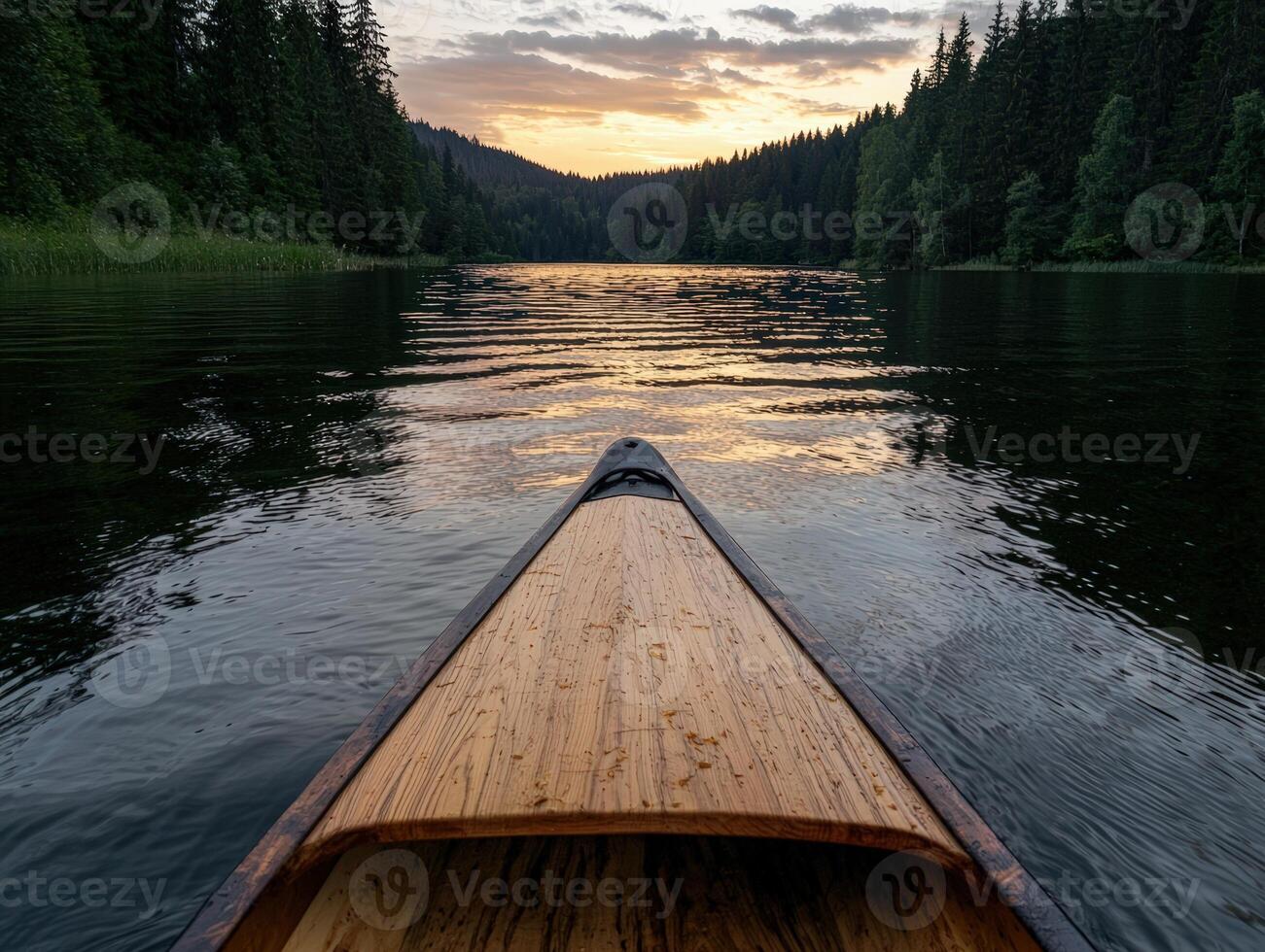 Canoe on calm lake at sunset surrounded by forest photo