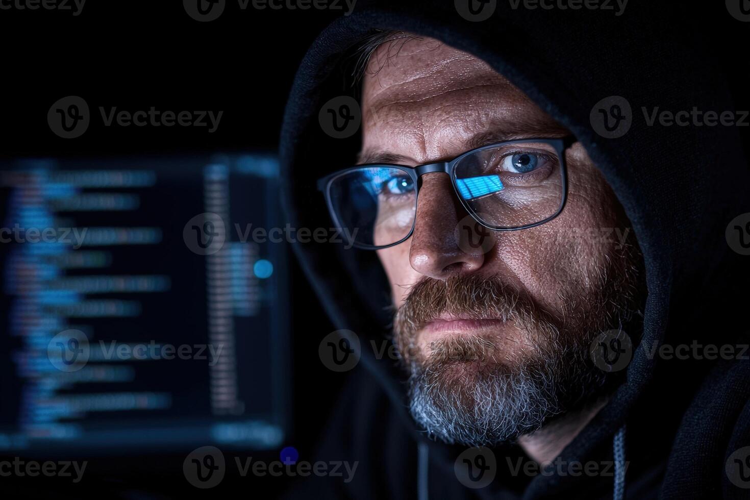 Hacker in hoodie with code reflected in glasses photo