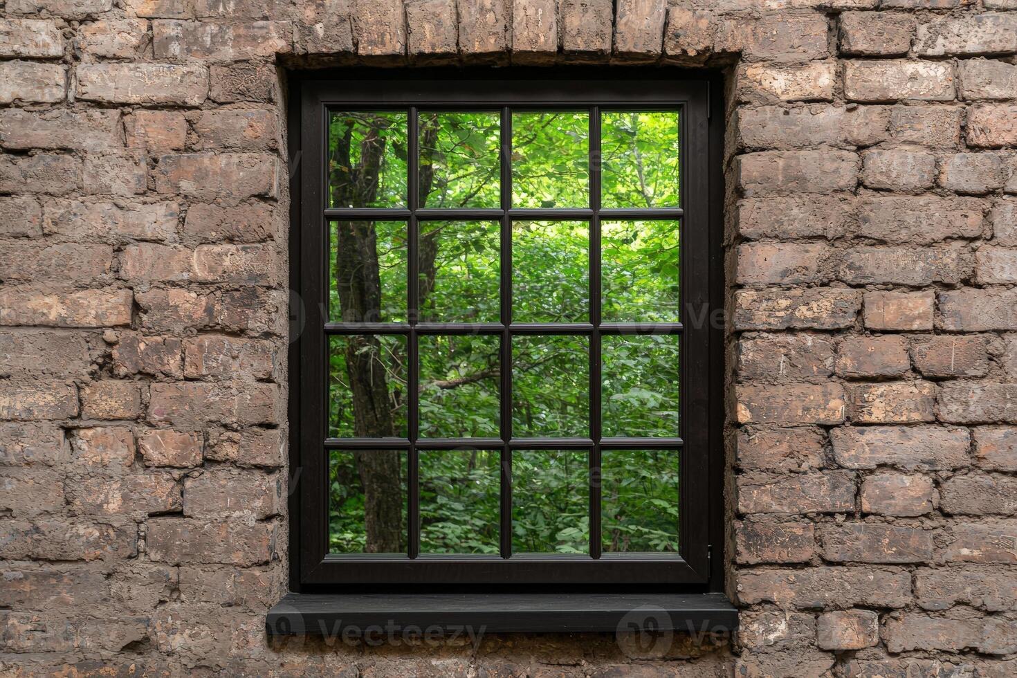 Rustic brick wall frames a window with green forest view photo