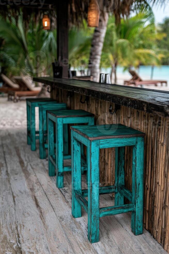 Rustic turquoise bar stools at a tropical beach bar photo