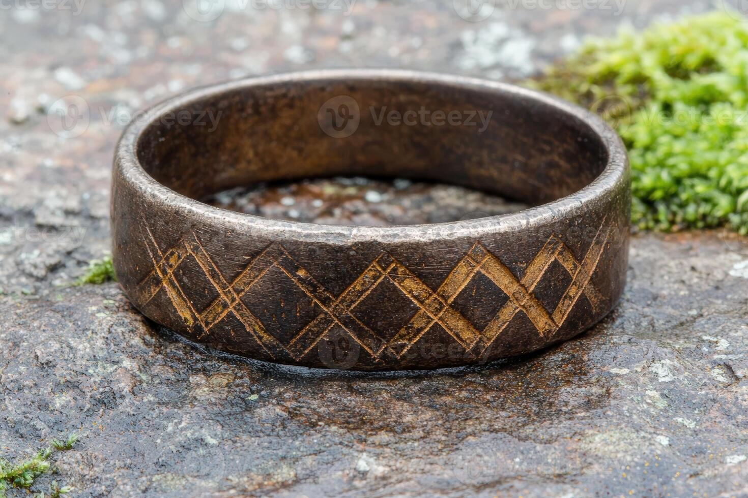 Rustic bronze ring with etched diamond pattern on stone photo