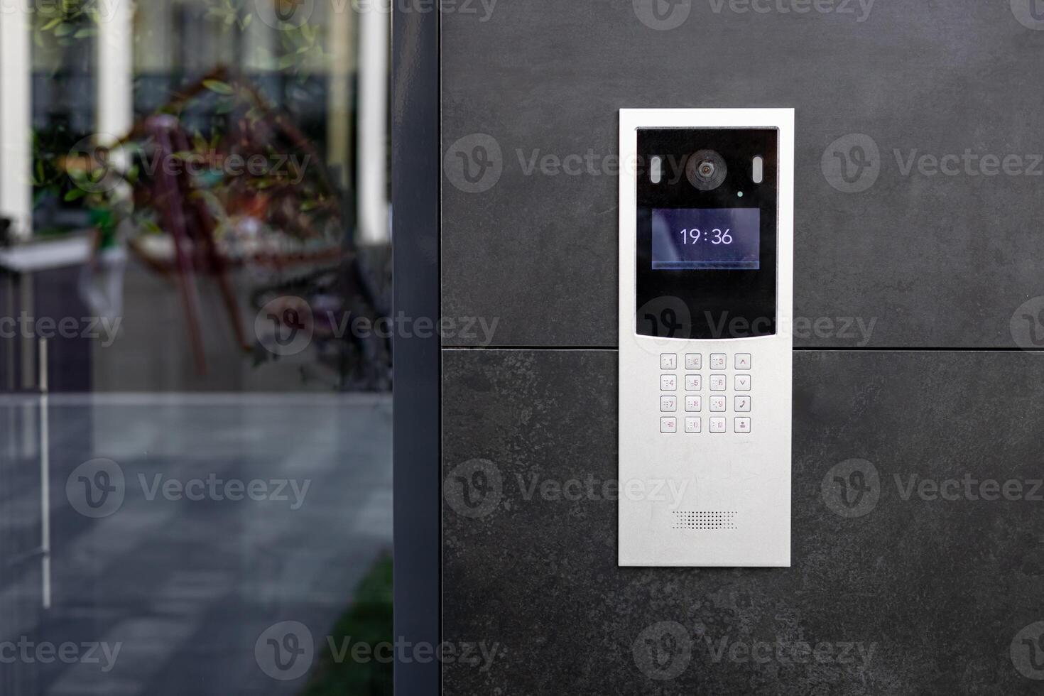 Entrance doorbell in a multi-apartment building, with a surveillance camera, on a dark wall. photo