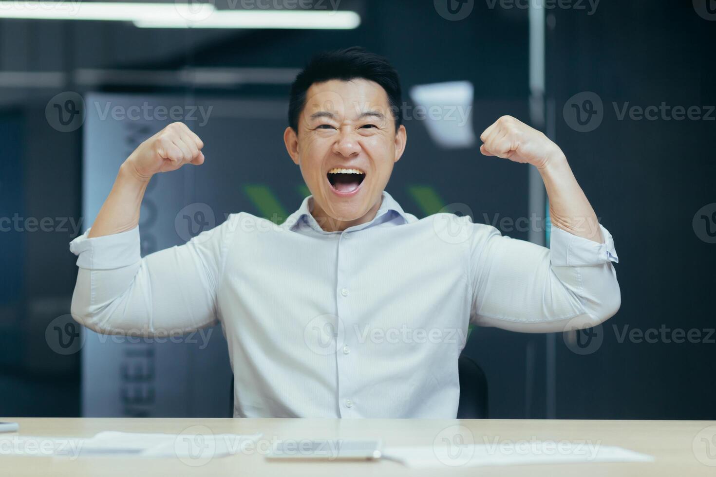 Asian super hero businessman looking at camera and smiling holding hands up gesture of strength and confidence man working in office at work photo