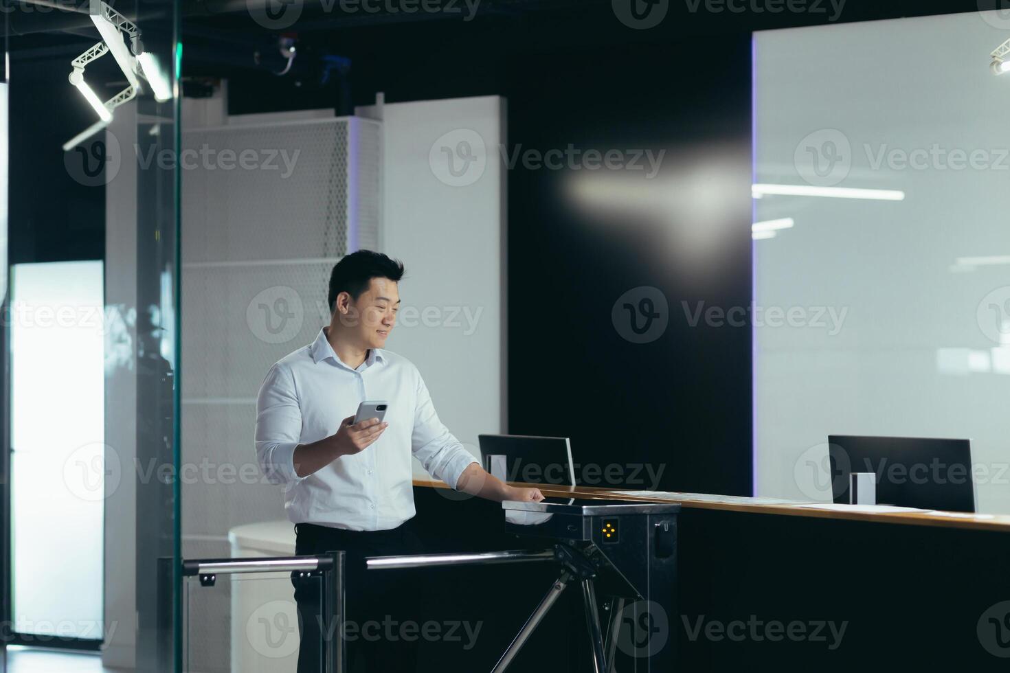 Asian worker enters the office through the door, opens the lock with a plastic card, a businessman in a shirt with a phone photo
