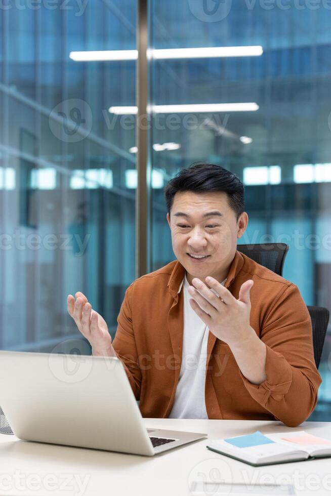 Asian man enthusiastically participates in a conference at his office, using gestures to explain his ideas clearly and concisely. photo
