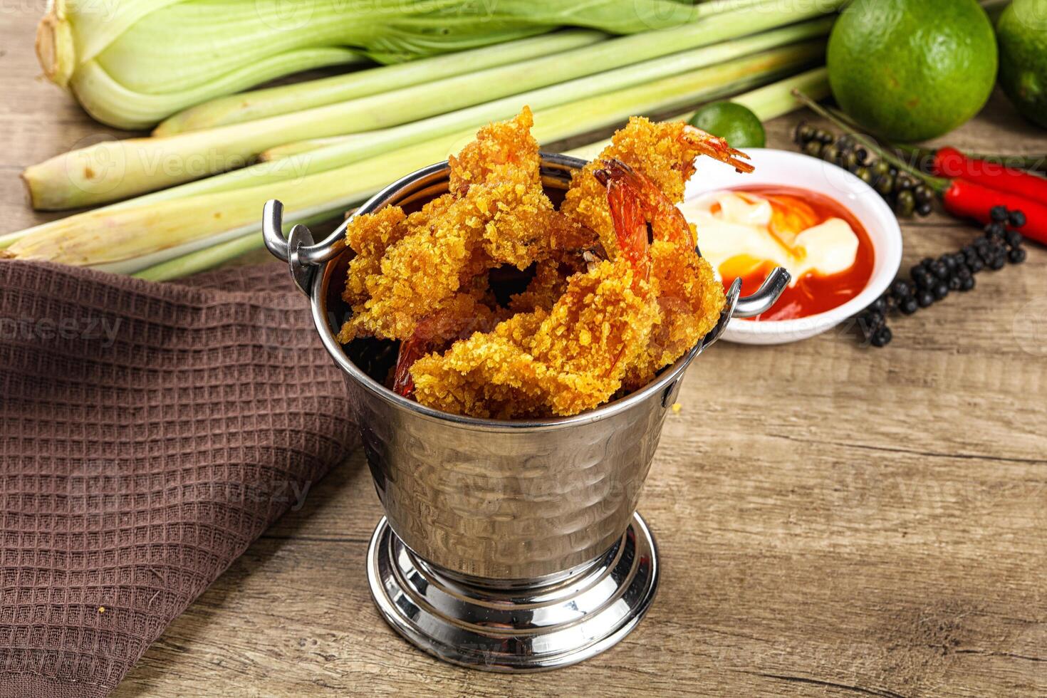 A silver container with fried shrimp and other food photo