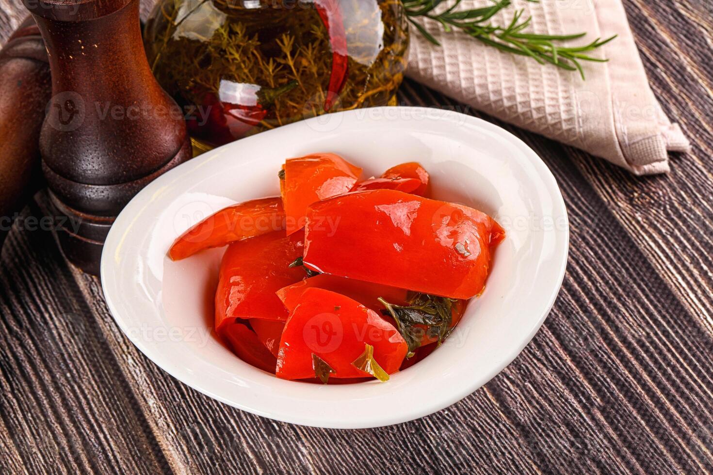 A bowl of red peppers and a bottle of olive oil photo